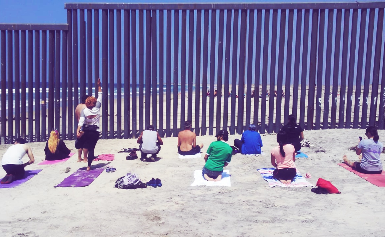 Practican yoga separados por muro fronterizo