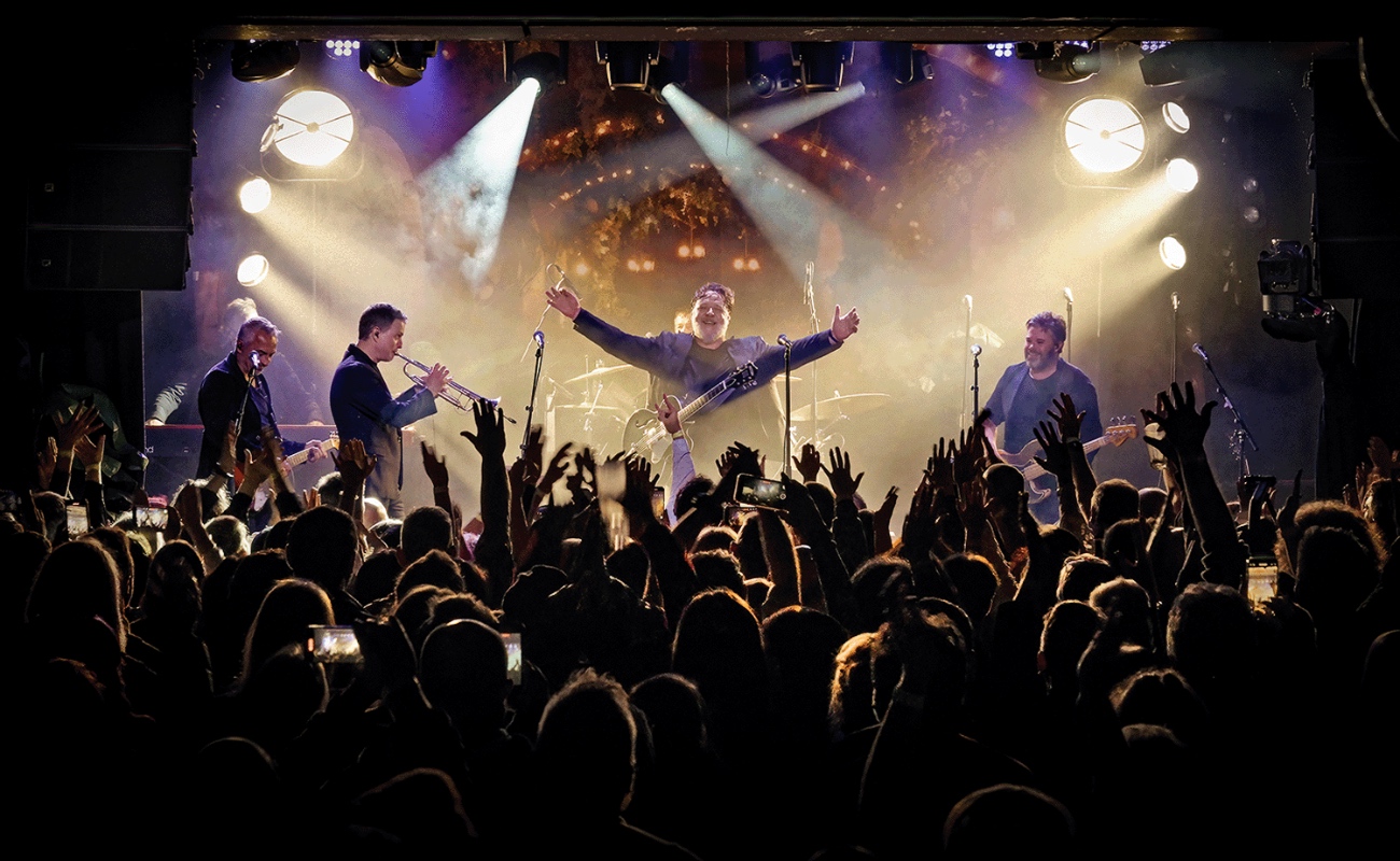 Russell Crowe durante una presentación con su banda Indoor Garden Party, en la que combina actuación, música y un estilo escénico cargado de energía.