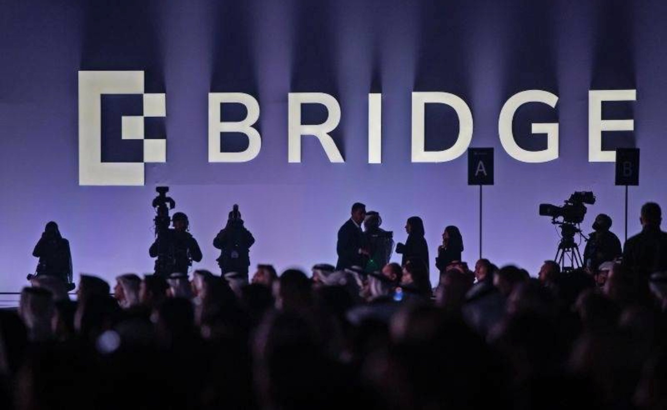 Participantes ingresan al ADNEC en Abu Dhabi, sede del BRIDGE Summit 2025, primeros minutos del evento inaugural.