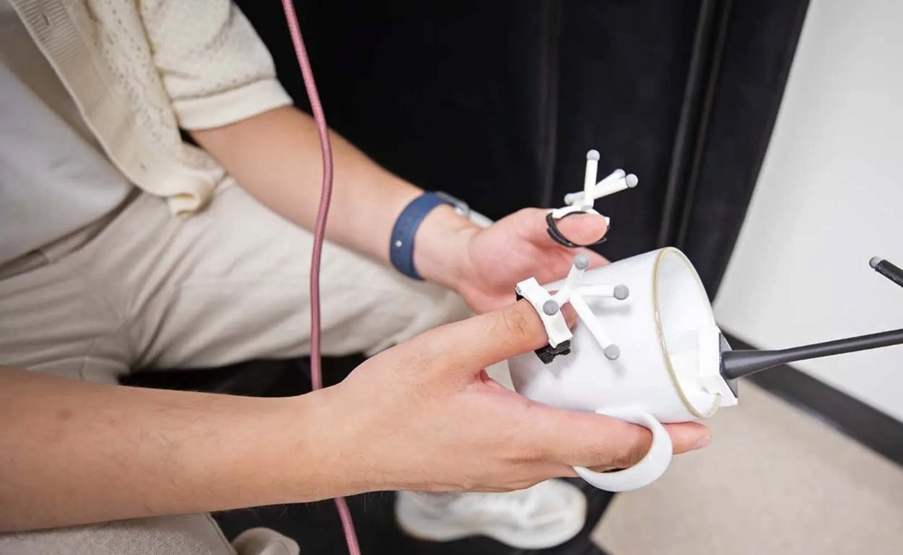 Daniel Honrales, estudiante de doctorado, demuestra cómo PropType superpone un teclado virtual sobre una taza para teclear en realidad aumentada.